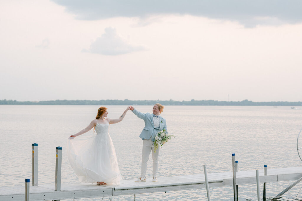 Bride and groom dancing on a dock at Battle Lake, Minnesota at sunset. 