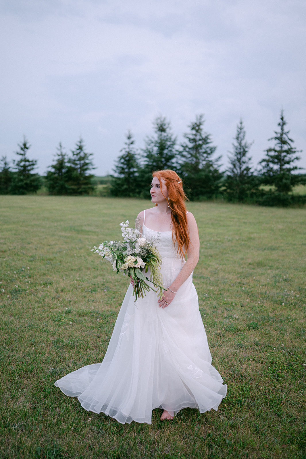 Whimsical portrait of the bride in an open field at sunset. 