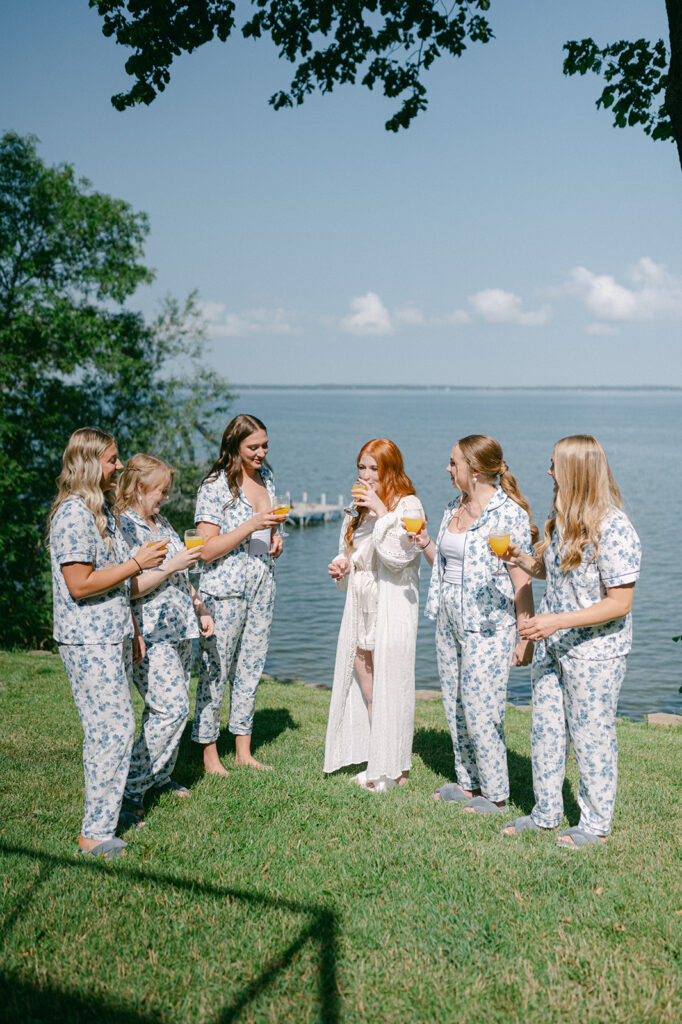 Bridal party sharing a mimosa toast by the lake during a garden party wedding at Battle Lake.