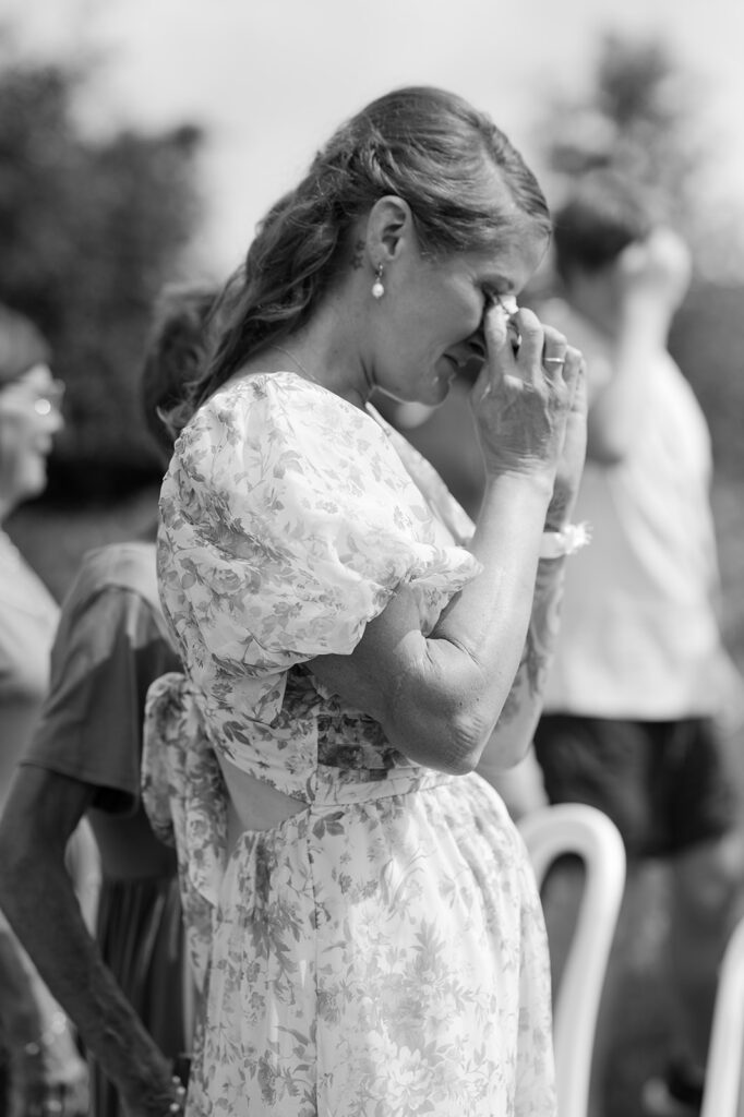 Documentary style portrait of the bride's mom getting emotional watching her walk down the aisle. 