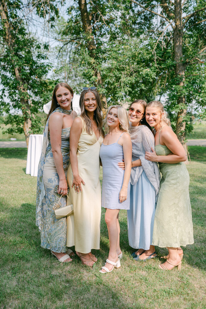 Bridesmaids in shades of blue and green mismatched dresses at cocktail hour. 