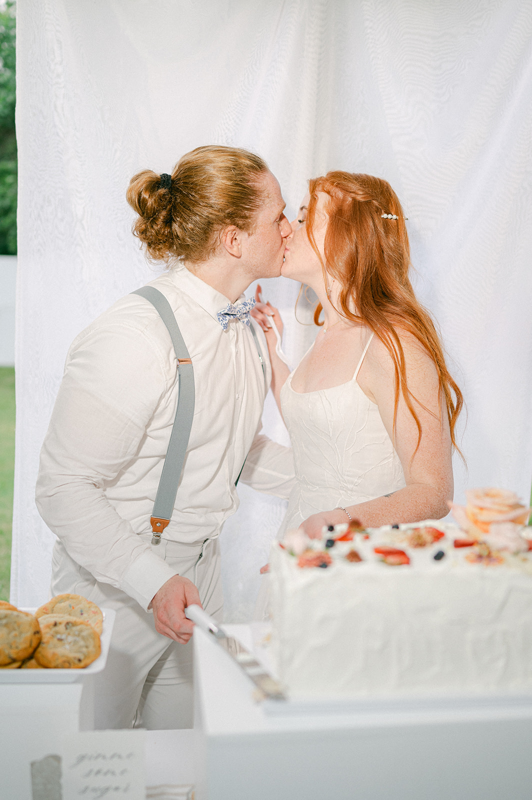 Bride and groom kissing after cutting their cake. 