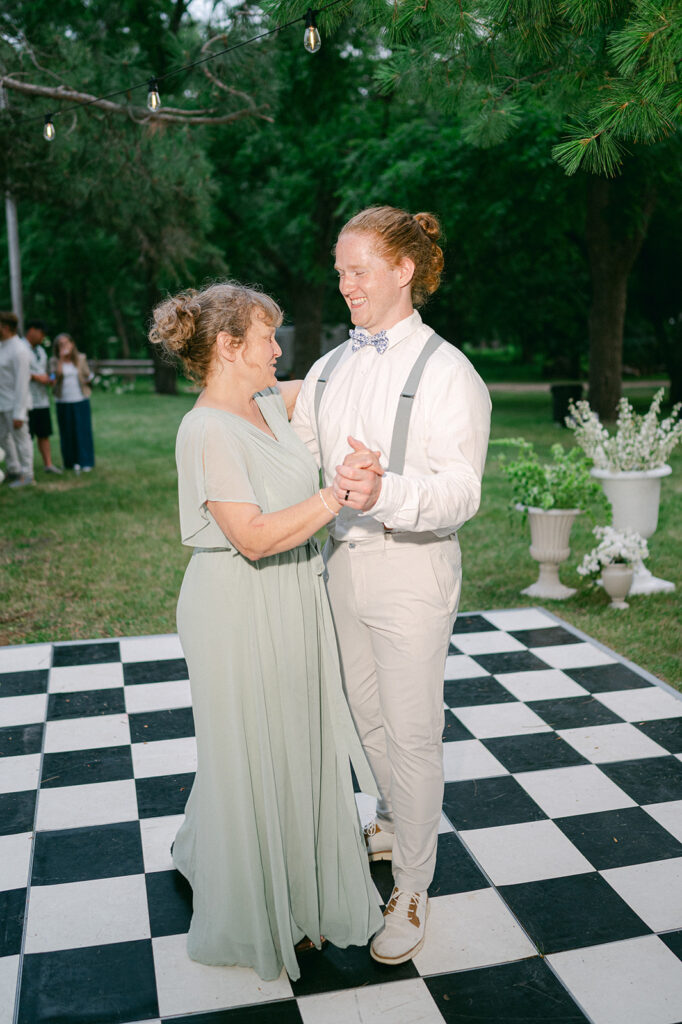 Mother-son dance on a checkered dance floor at a garden wedding in Minnesota. 