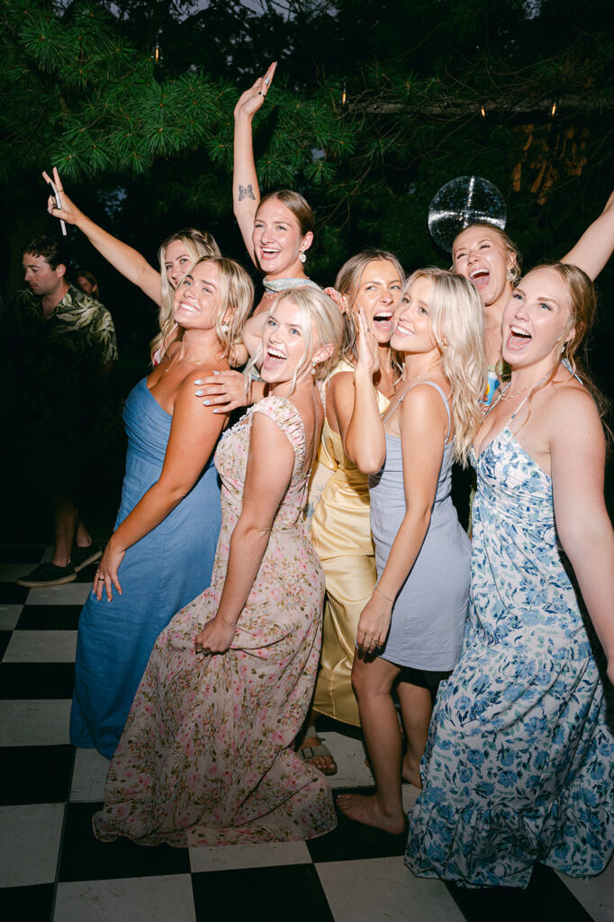 Direct flash wedding party portrait on a checkered dance floor. 