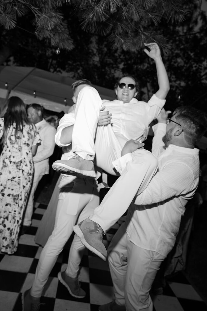 Documentary style black and white wedding dance party portrait. 