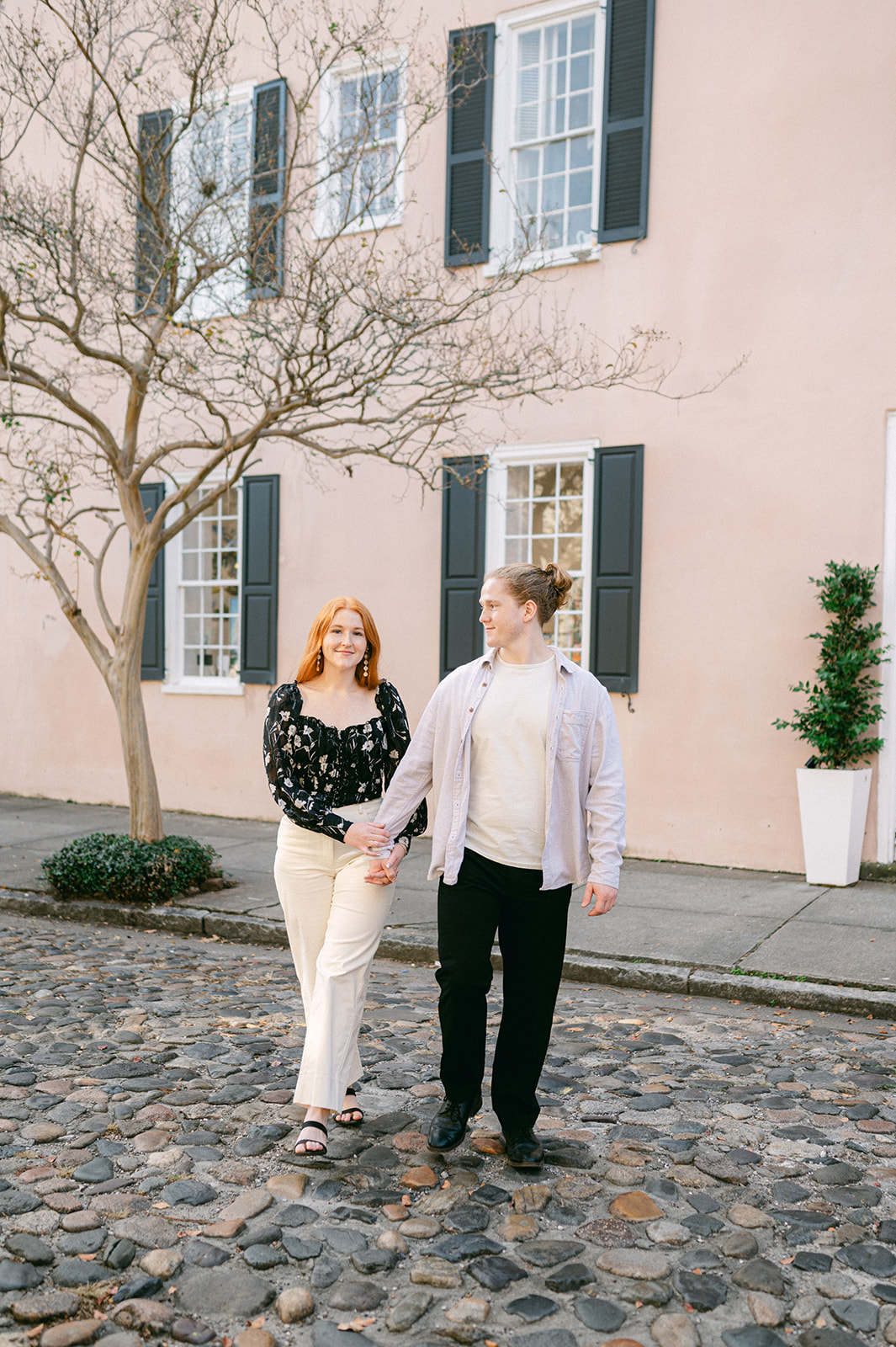 Pastel building downtown Charleston engagement photo. 