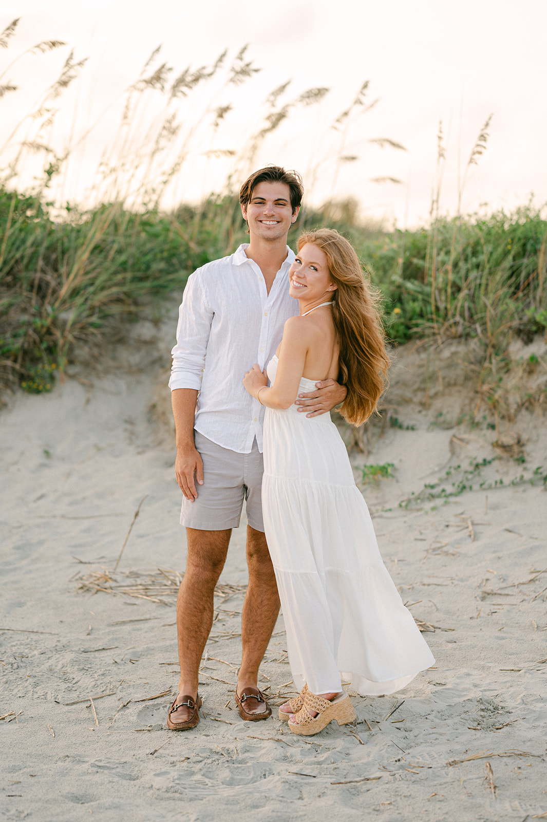 Beach engagement session with a flowy white dress in Charleston. 