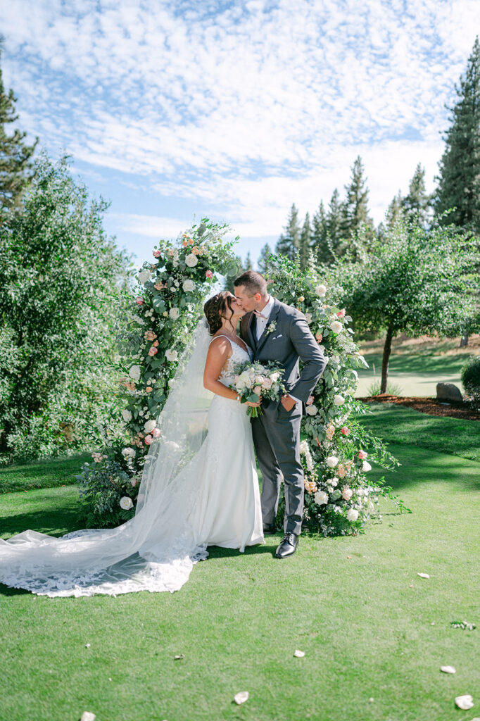 Bride and groom portraits in front of a floral arch in Lake Tahoe. 