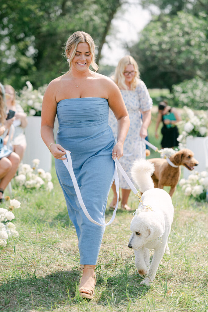 Bridesmaids walking dogs down the aisle at a garden party wedding captured by Sarah Woods Photography.