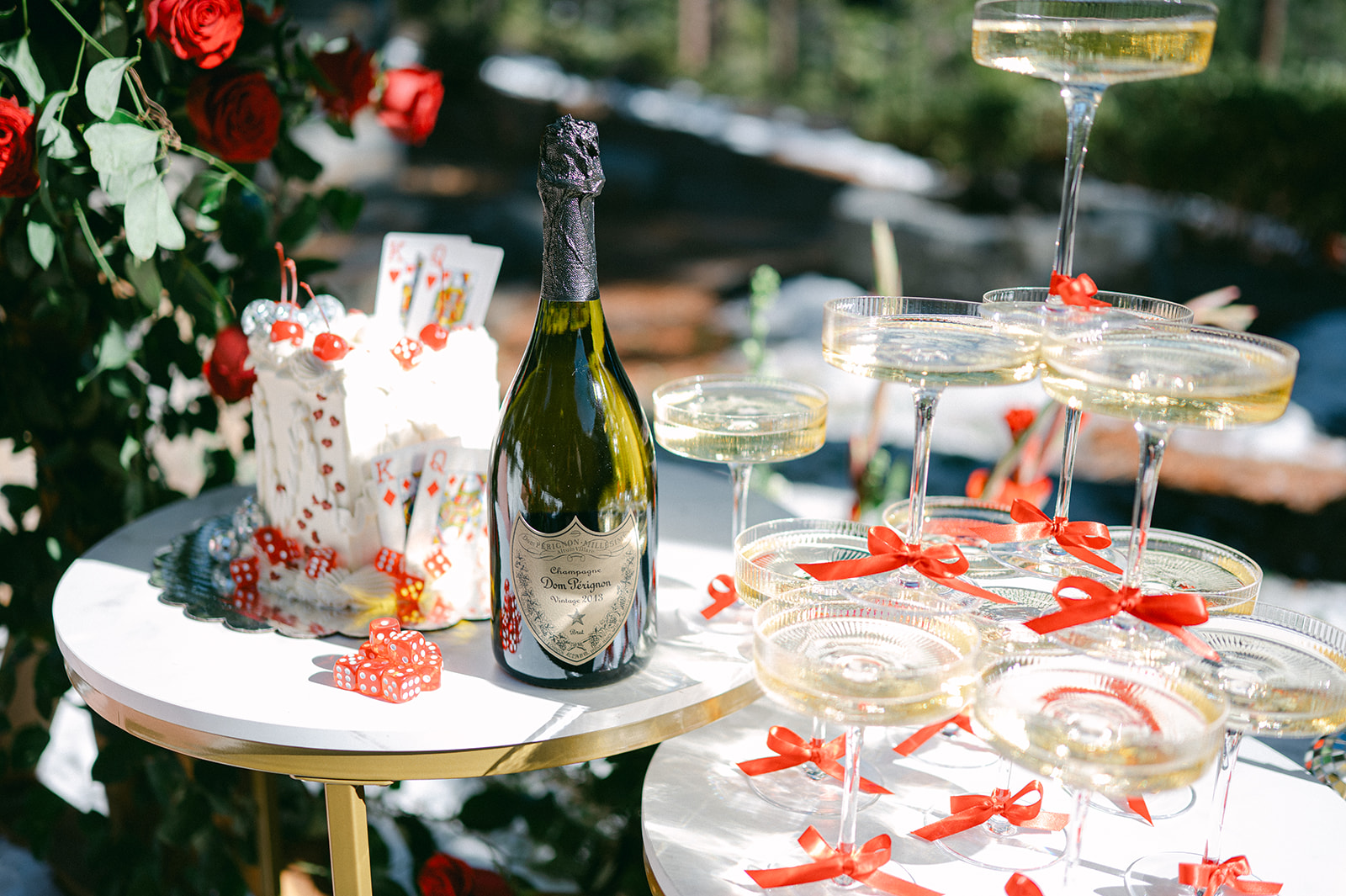 Romantic red themed proposal setup with a custom cake and champagne tower.