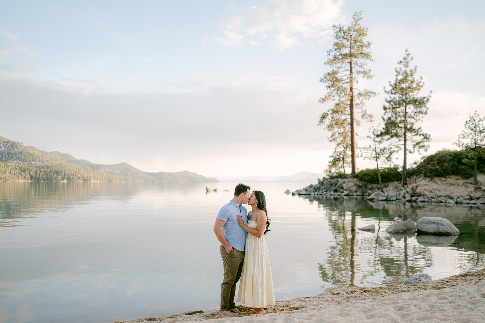 Couple kissing during their beach proposal and engagement session at Sand Harbor.