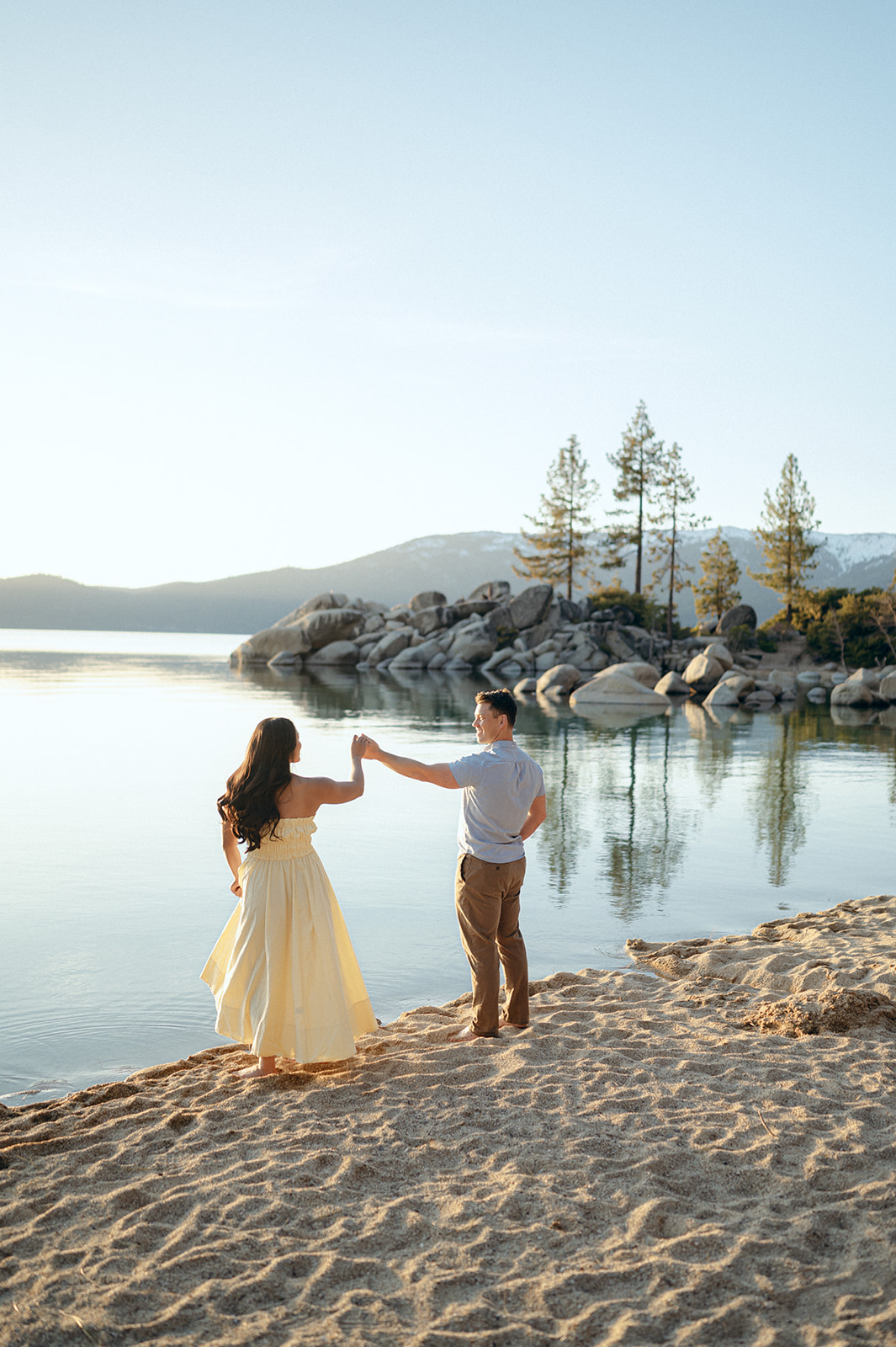 Couple dancing on the beach at Sand Harbor during their summer engagement session.