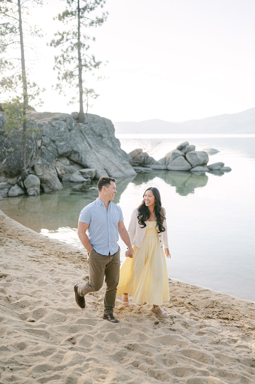 Couple walking on the beach after their Sand Harbor proposal in Tahoe.