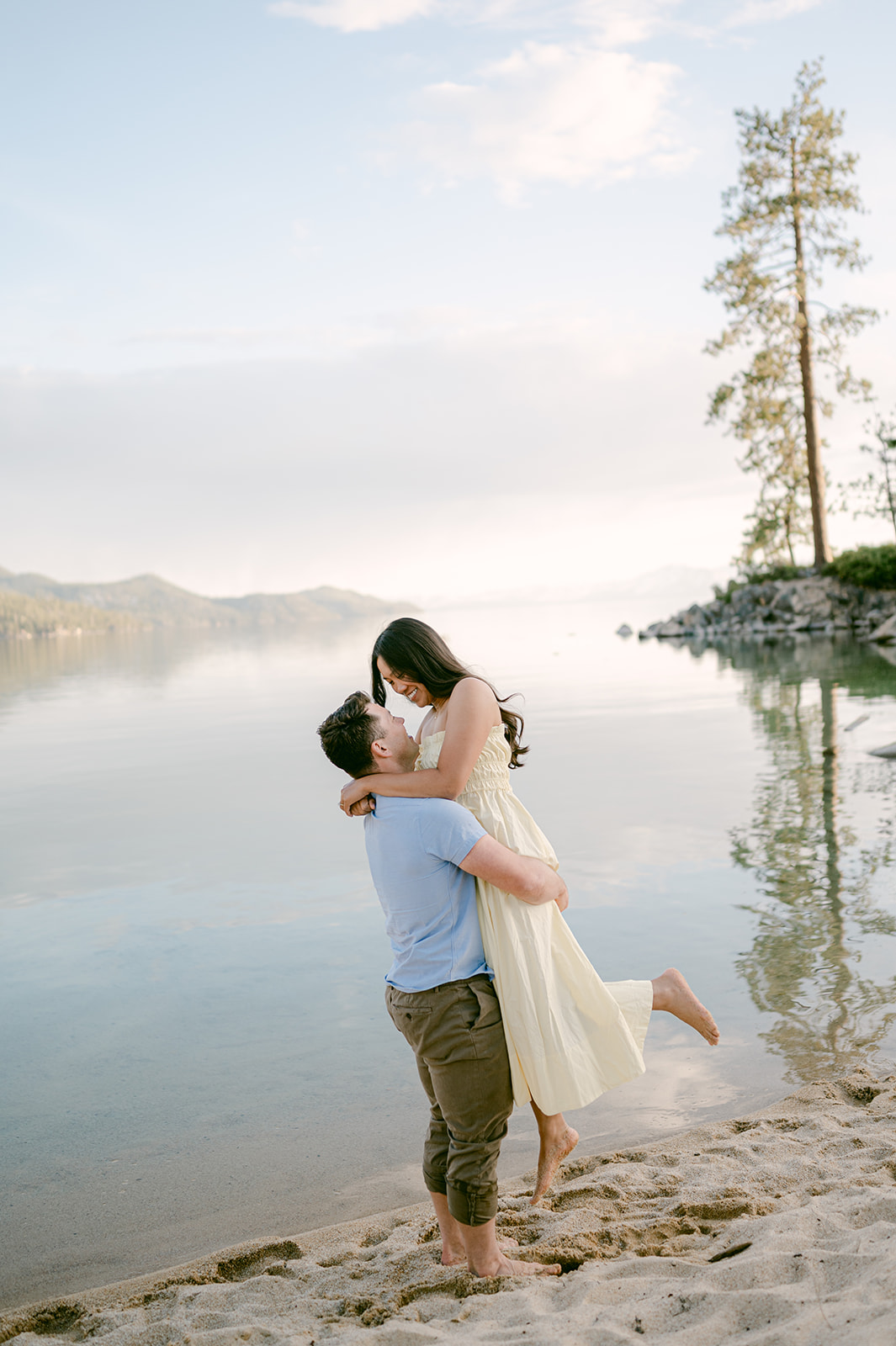 Man picking up his fiancé in front of Lake Tahoe after their proposal.