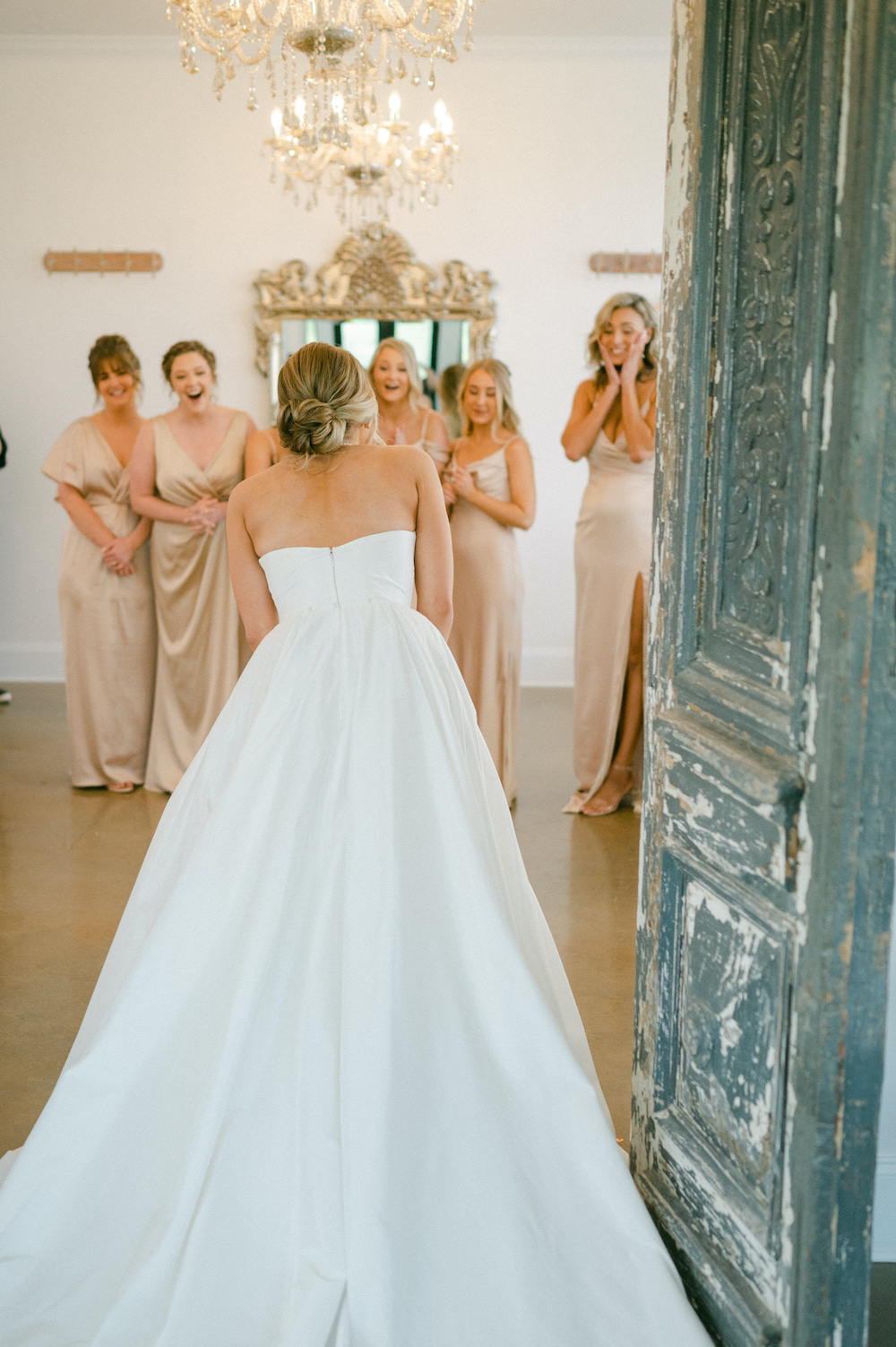 Bridesmaids reacting to seeing the bride for the first time—a must-have wedding photo.