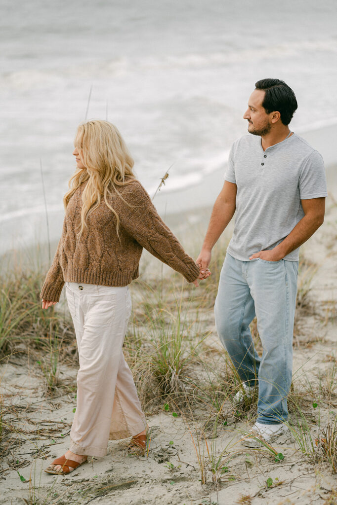 Beach engagement photos with casual outfits.