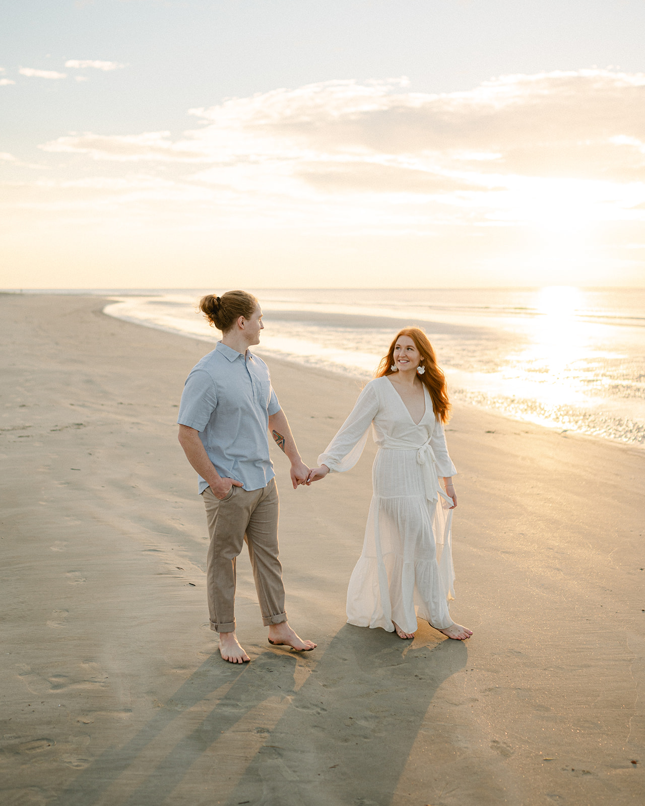 Beach engagement photo outfits with a flowy white dress. 