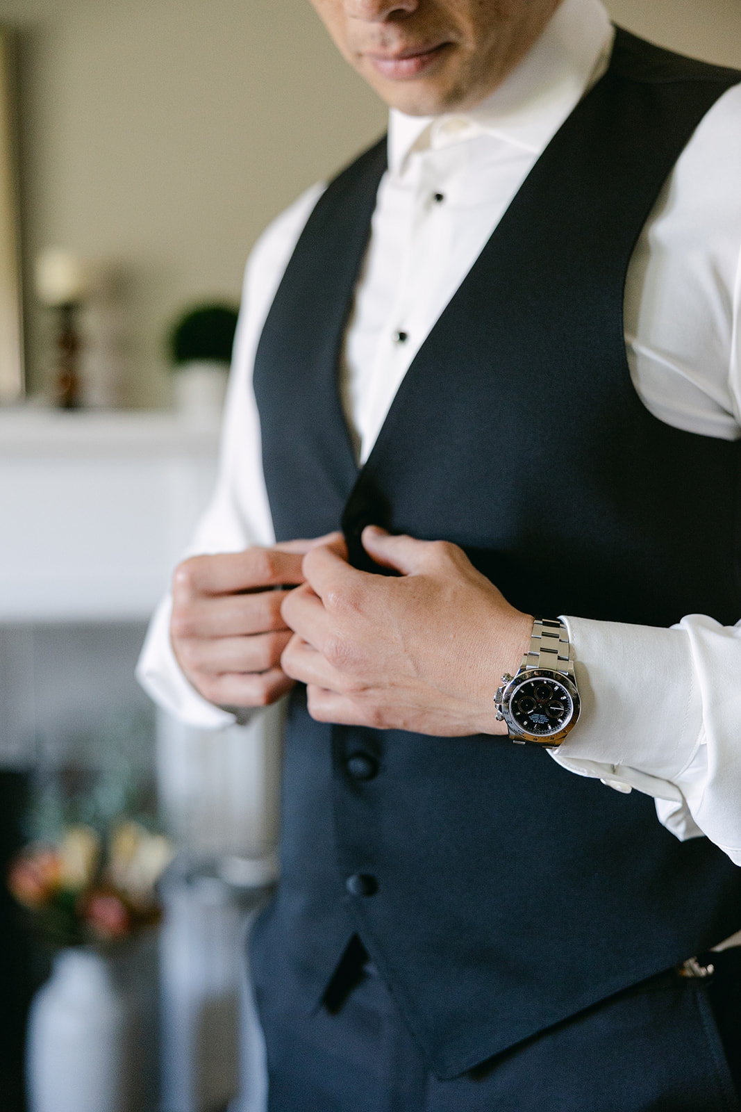 Groom putting on his vest | modern groom getting ready photo.