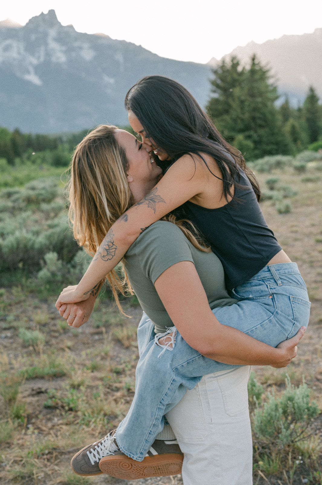 Romantic wlw anniversary session in the Grand Tetons with laid-back outfits and rustic mountain scenery.