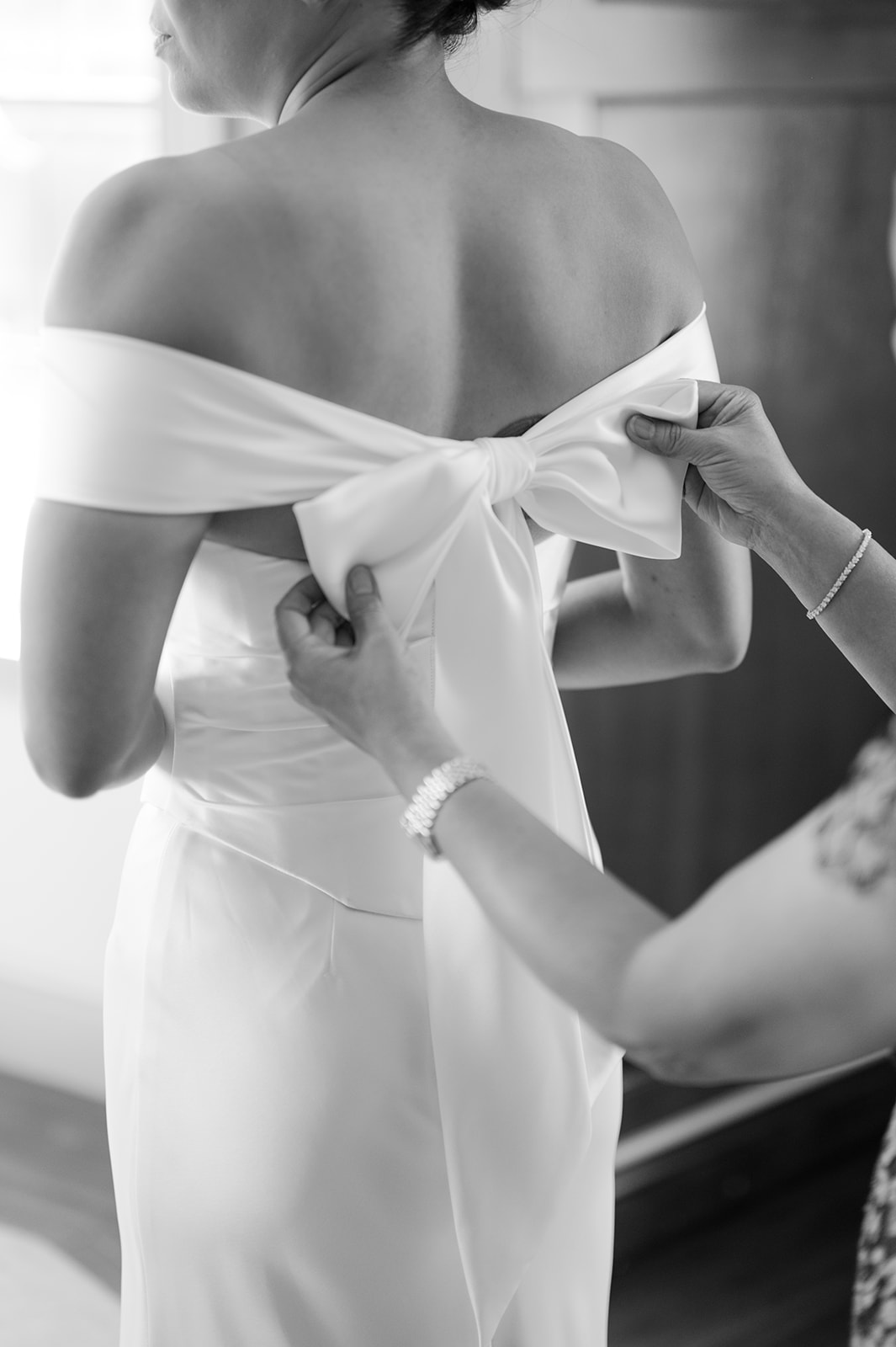 Mom helping bride into her dress | candid wedding photography detail.