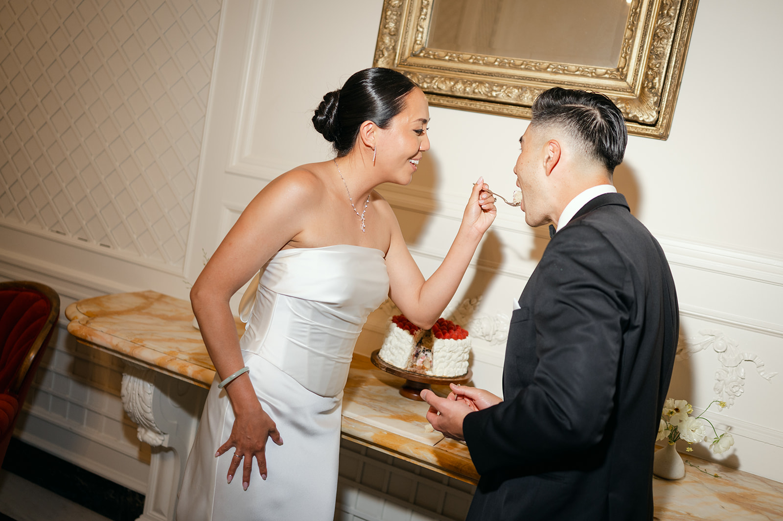 Bride feeding groom cake candid wedding photography.