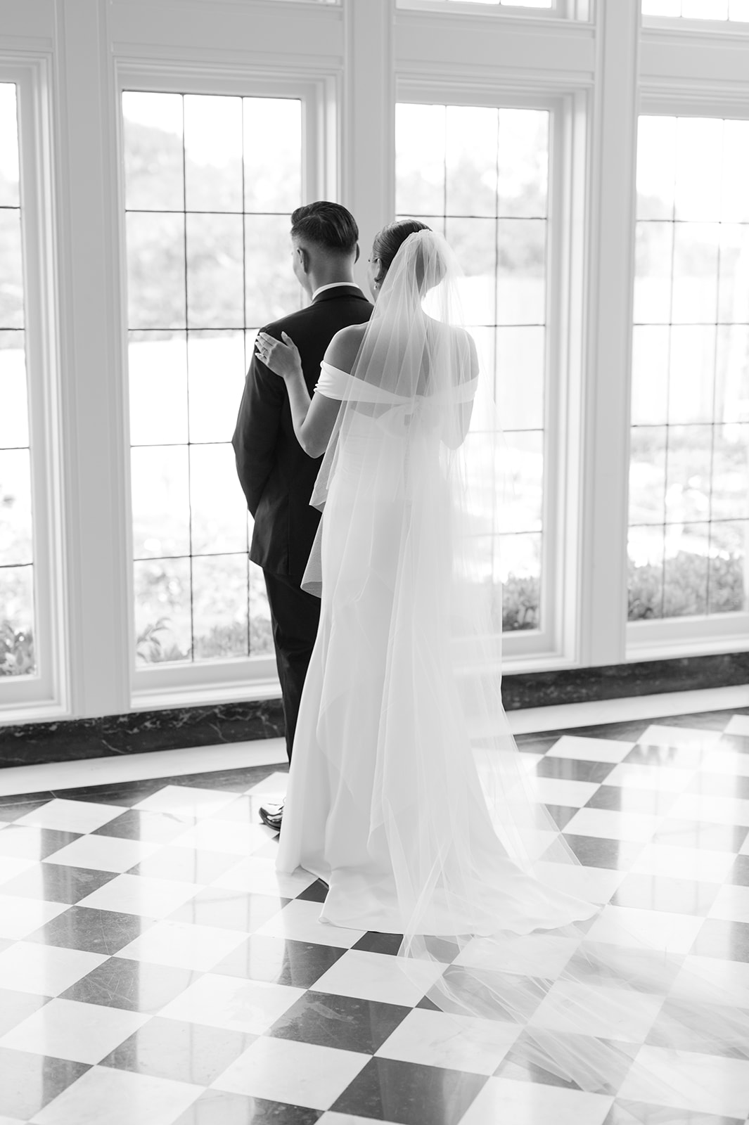 Couple’s first look inside Kohl Mansion on black and white checkered floors.