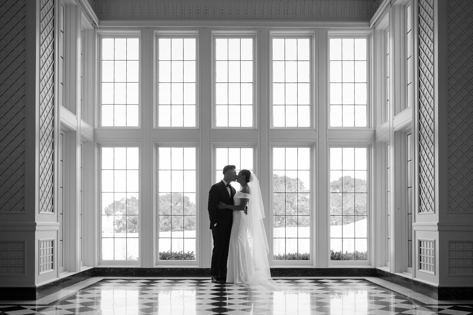 Editorial black-and-white photo of couple kissing after first look at Kohl Mansion.