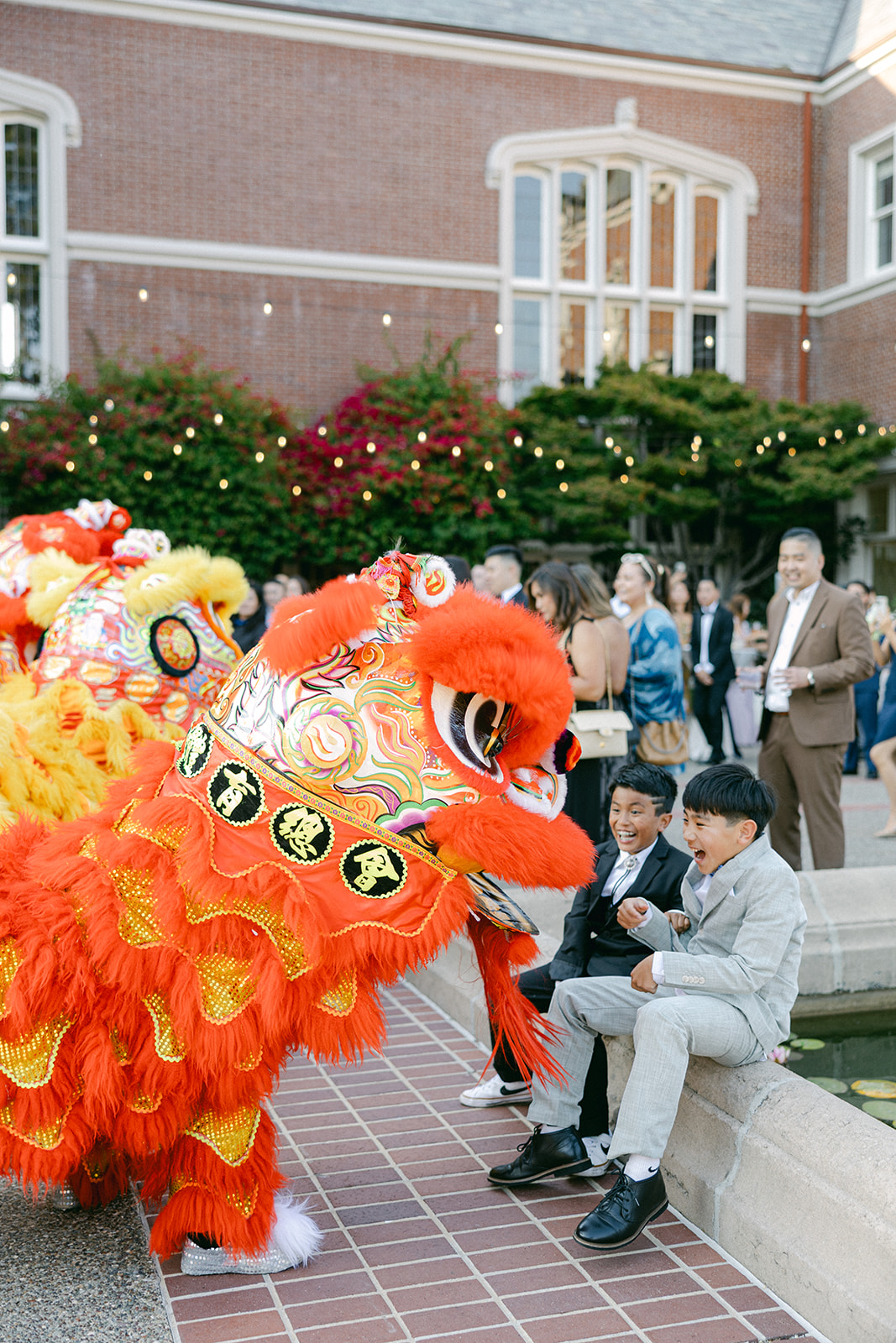 Guests reacting with excitement as lion dancers enter the courtyard.