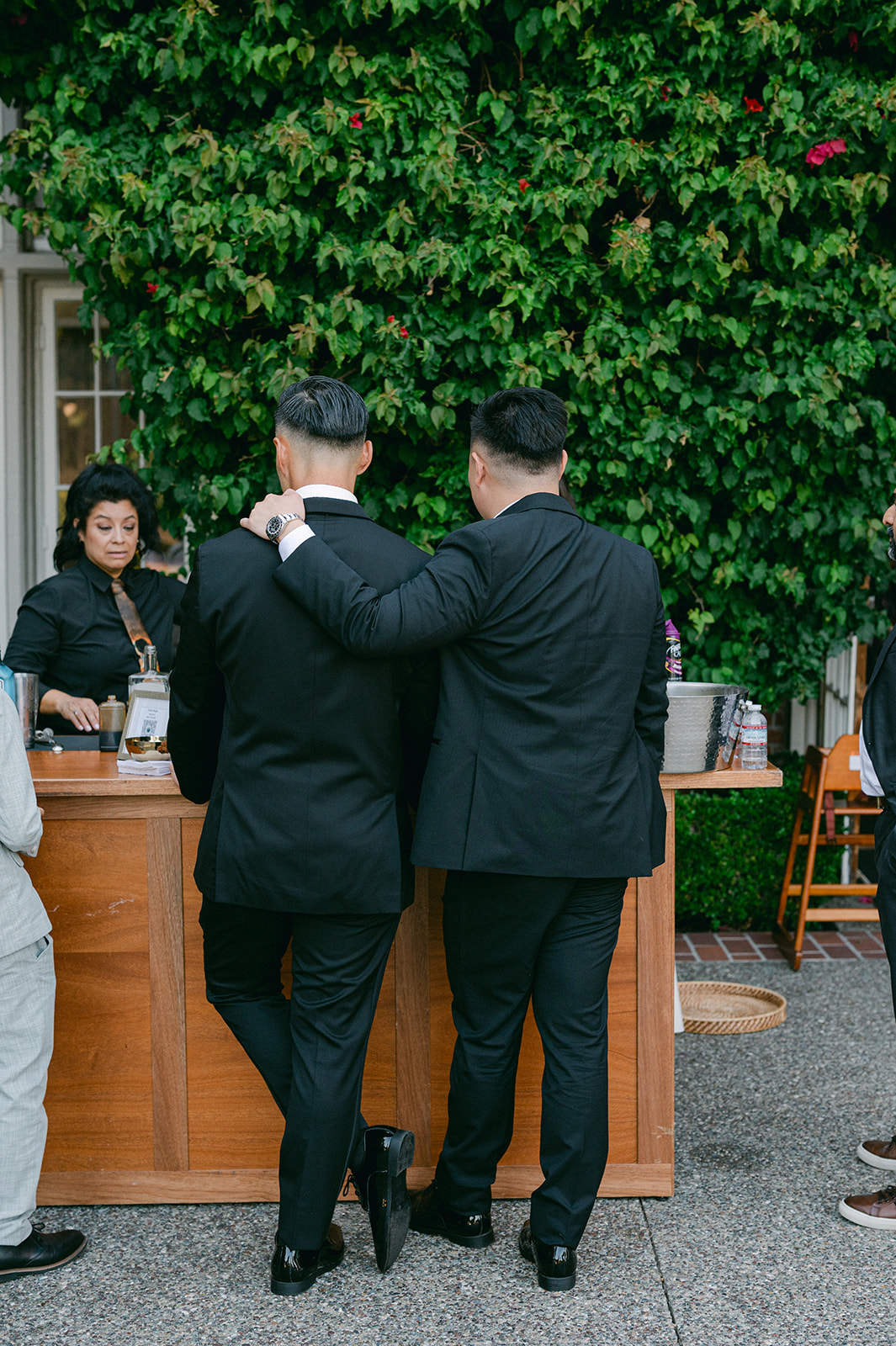 Candid moment of groom and groomsmen at the bar during cocktail hour.