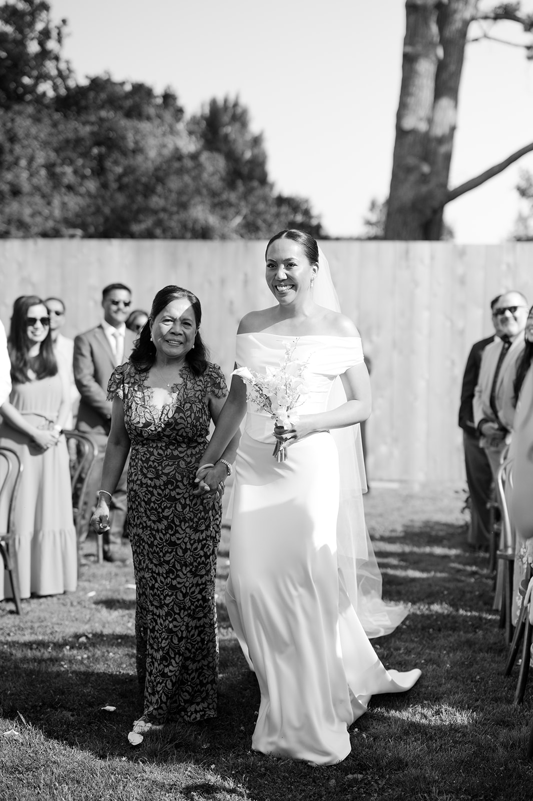 Bride and mom walking down aisle together at Kohl Mansion.