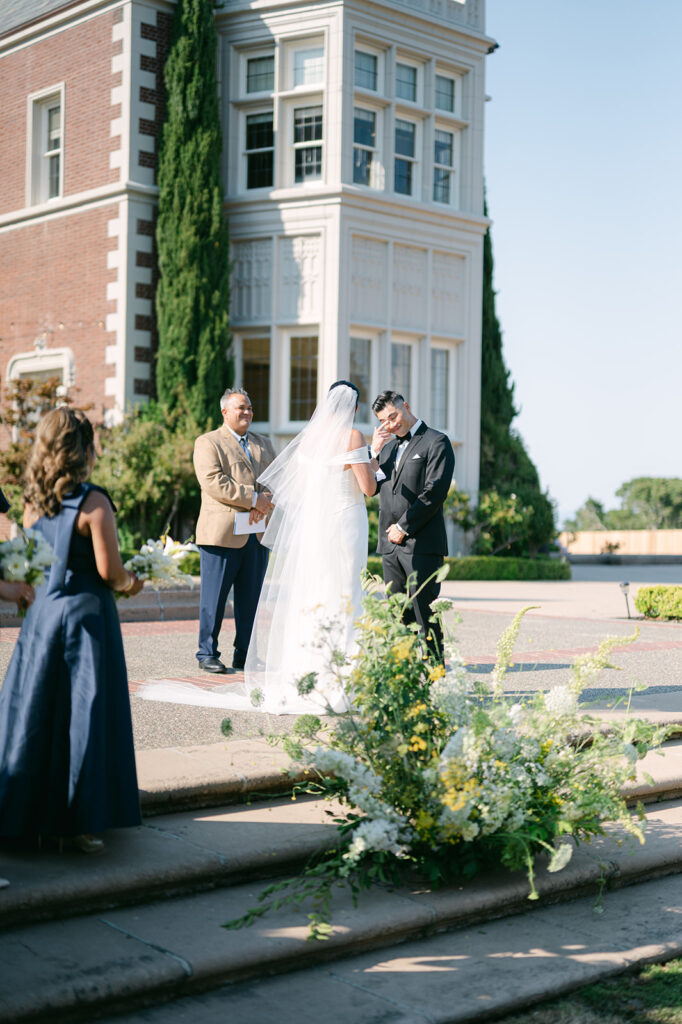 Groom wiping away tears at bride during vows at Kohl Mansion wedding