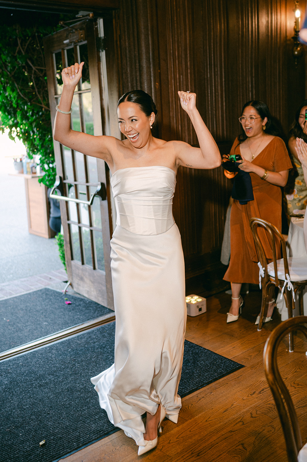 Candid photo of bride entering the reception. 
