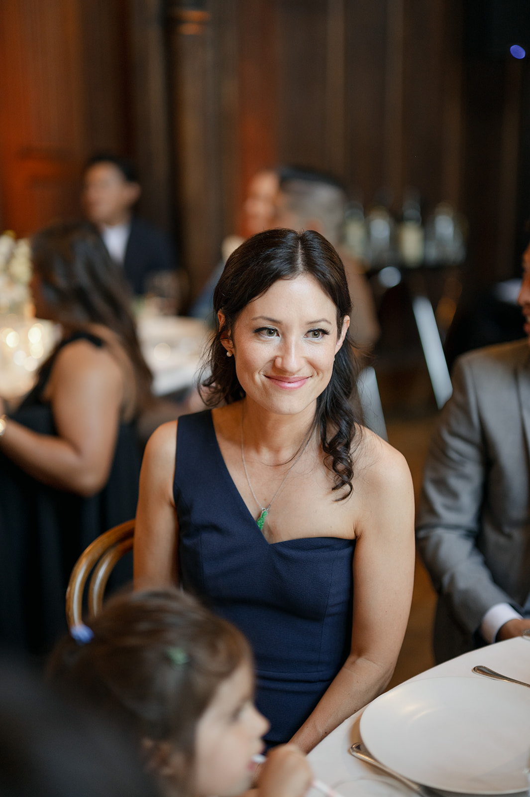 Candid guest seated around tables inside Kohl Mansion wedding reception.