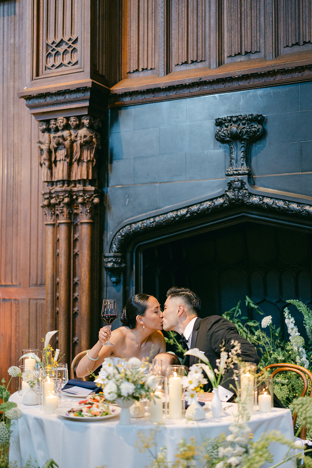 Bride and groom kissing at sweetheart table.