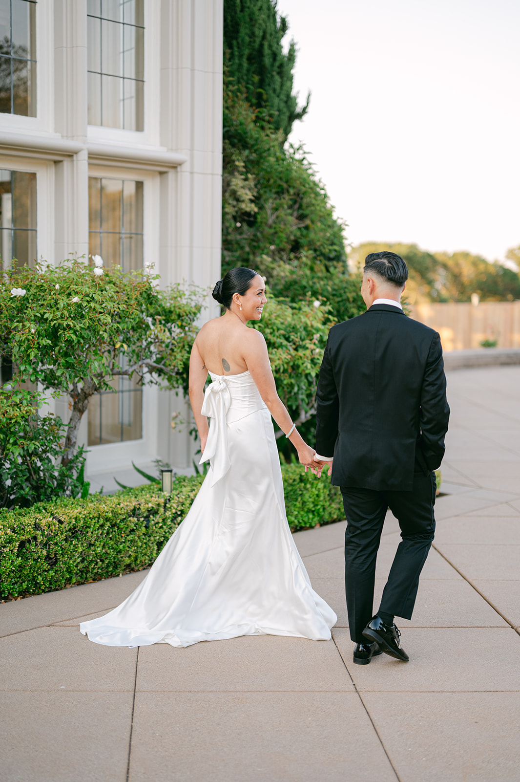 Bride and groom walking hand-in-hand outside Kohl Mansion wedding.
