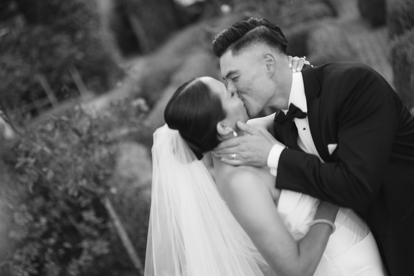 Black-and-white candid kissing wedding photo. 