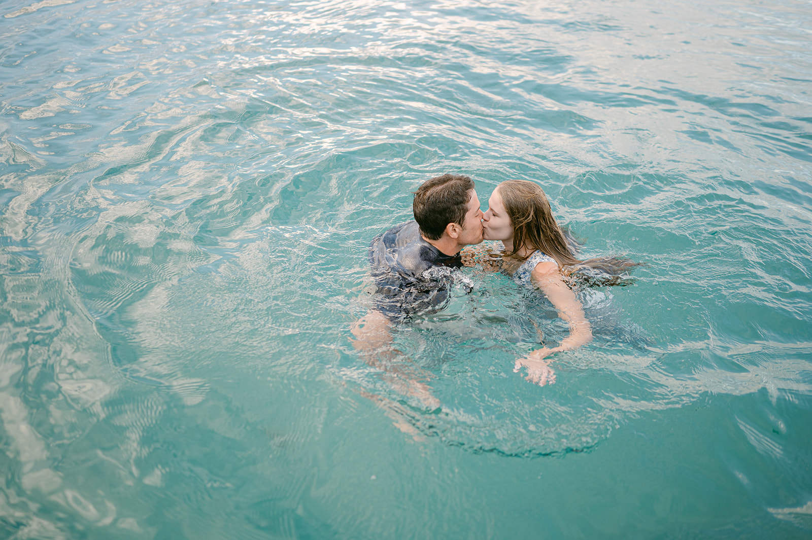 Couple kissing in the water after jumping in the lake fully clothed | Candid Lake Tahoe engagement session.