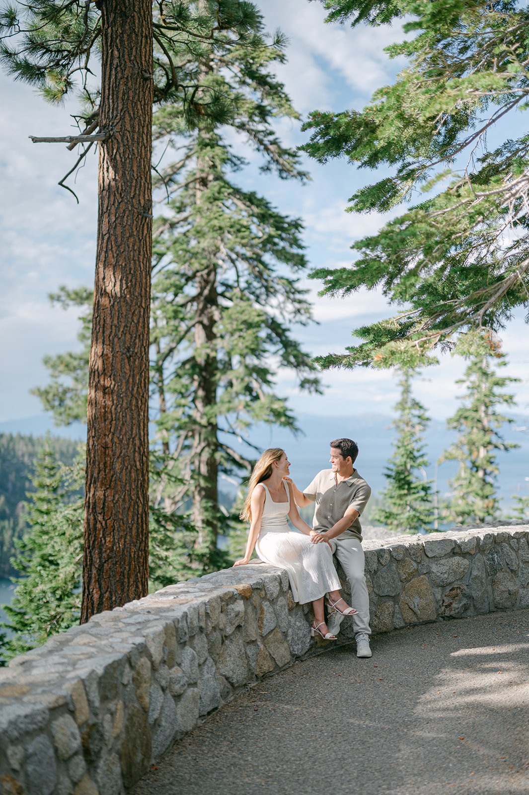 Couple embracing on trail above Emerald Bay | candid Lake Tahoe engagement photo.