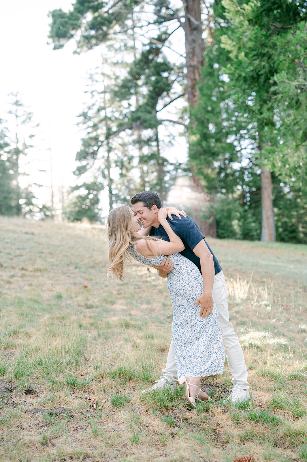 Couple leaning in for a kiss framed by trees at Sugar Pine Point State Park. 