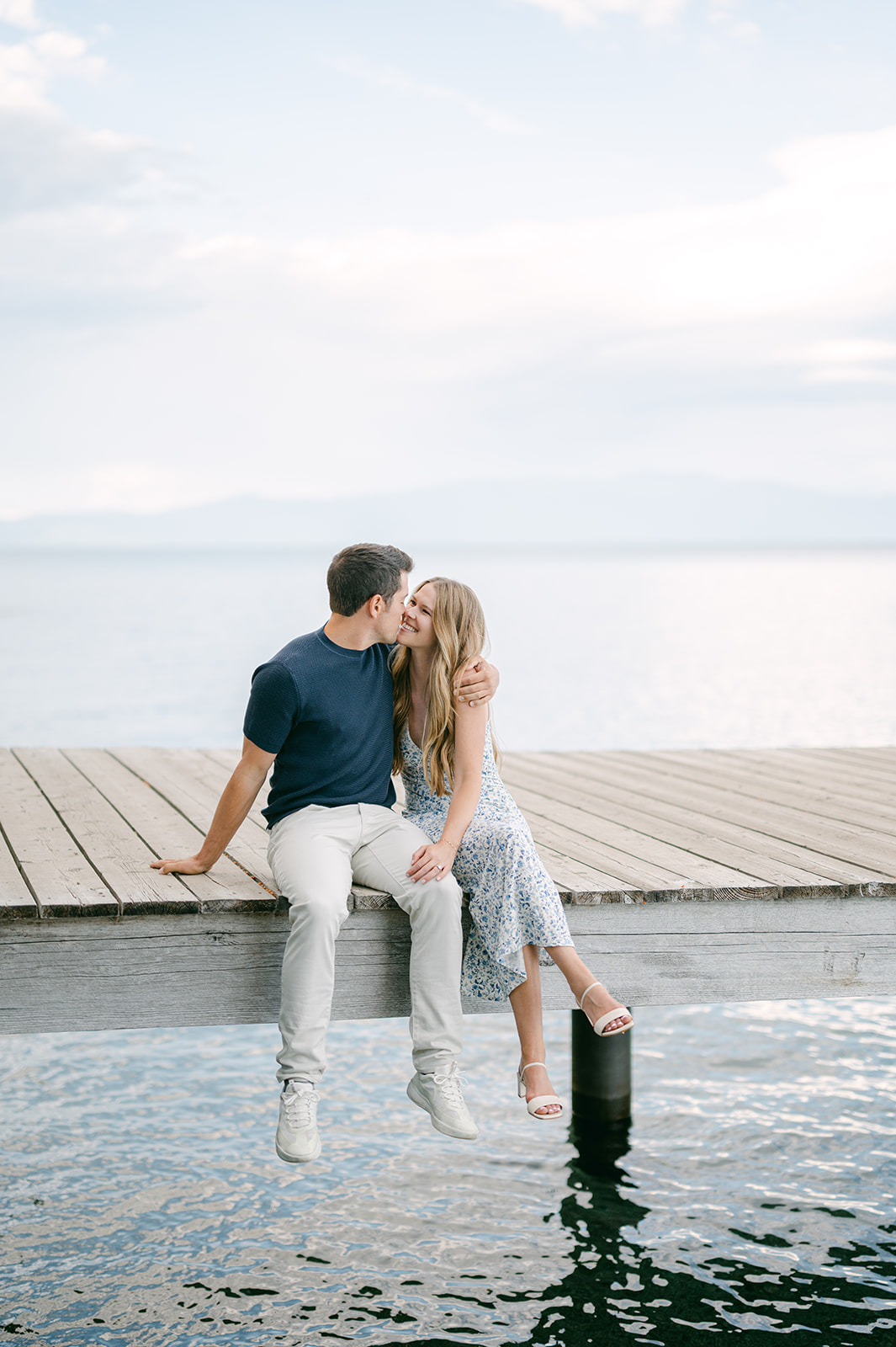 Bride and groom-to-be sitting on dock at Sugar Pine, Lake Tahoe. 