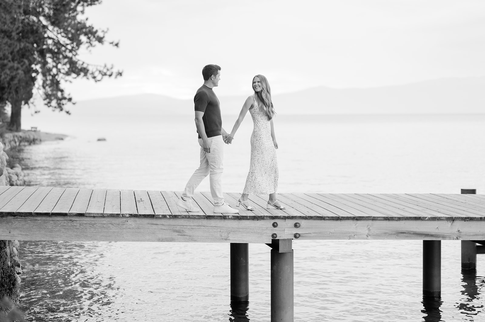 Couple walking down wooden pier at Sugar Pine State Park | Lake Tahoe engagement photography.
