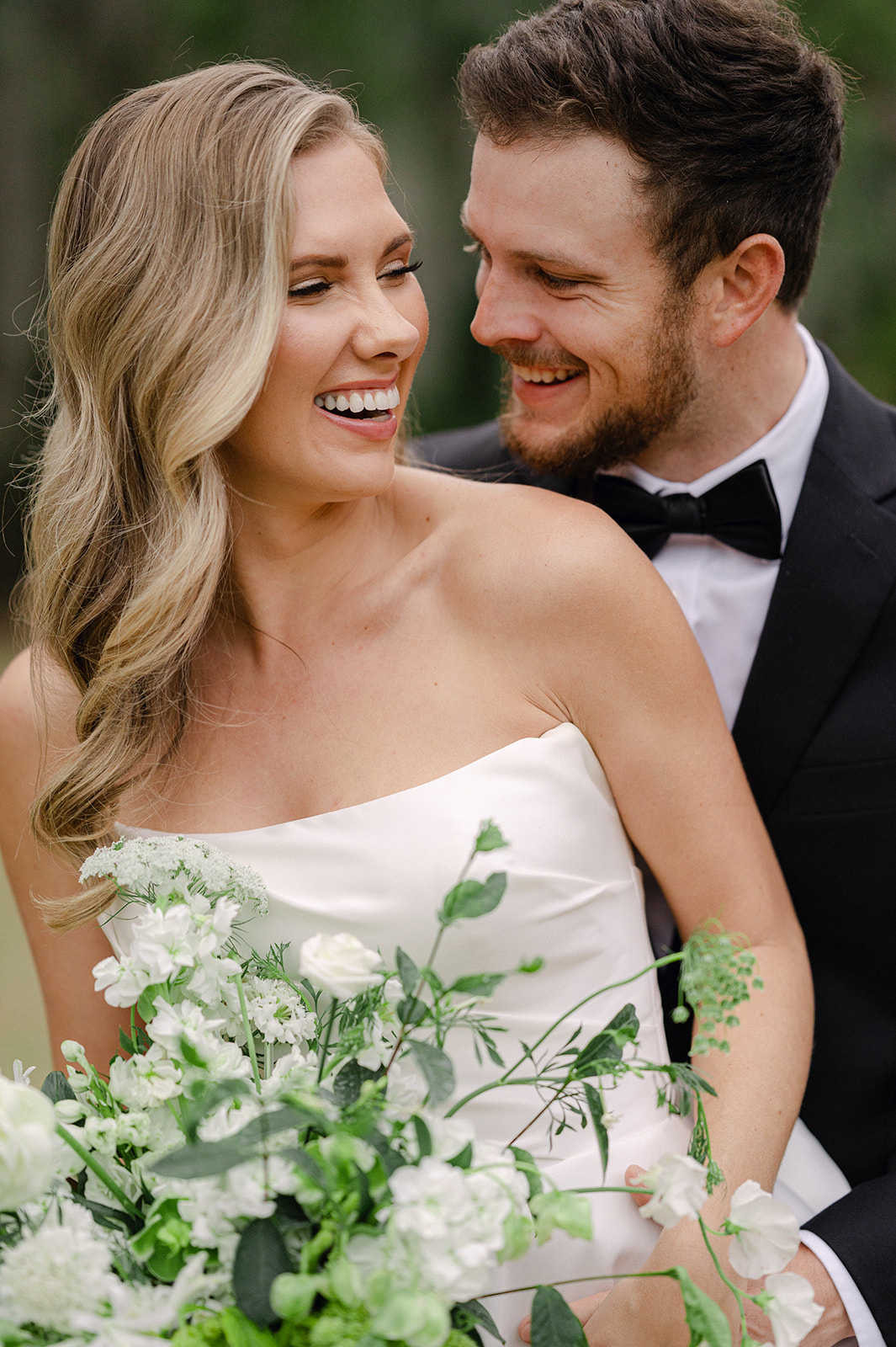 Bride and groom sharing a candid moment during portraits.