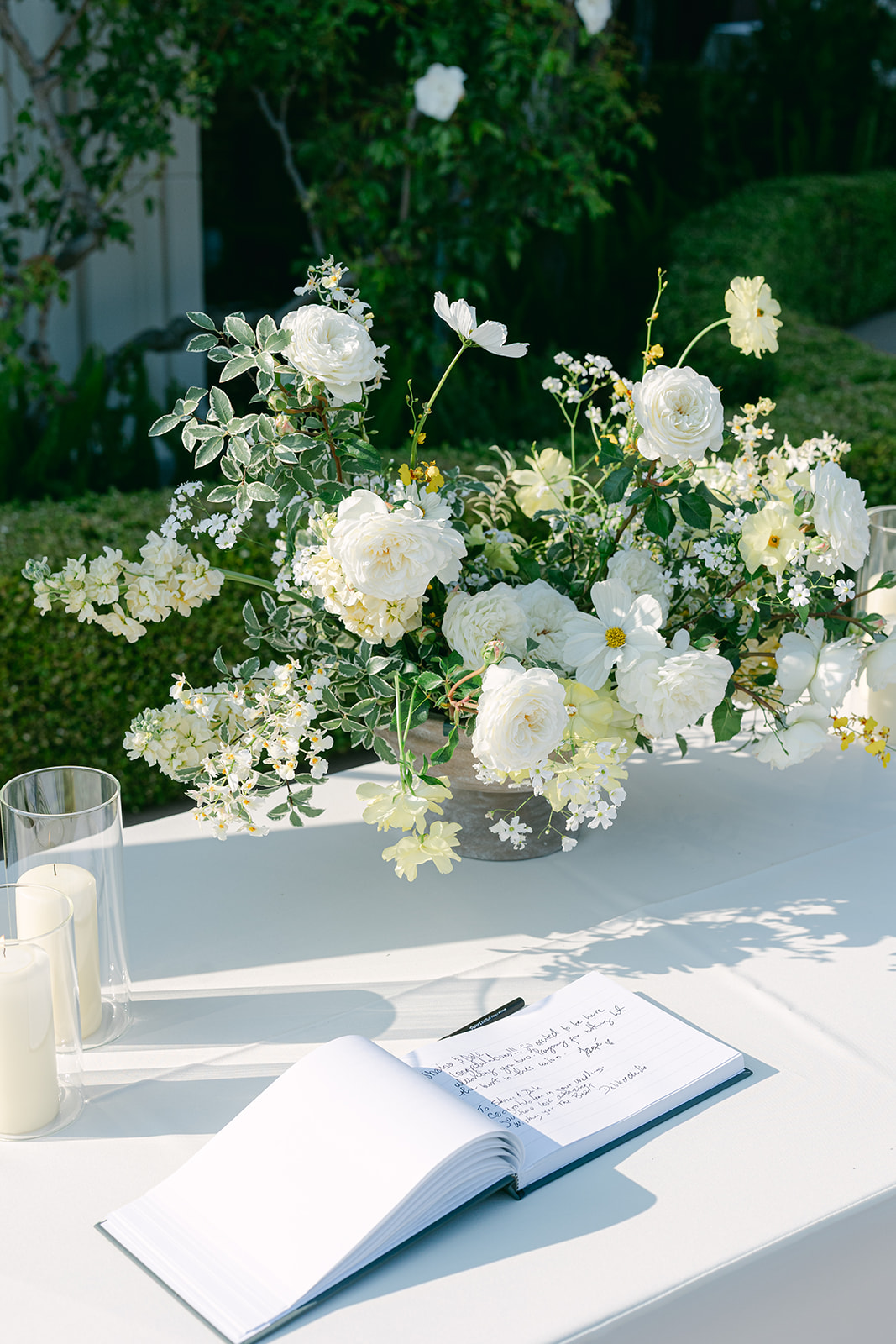 Wedding welcome table with florals, candles and the guest book.