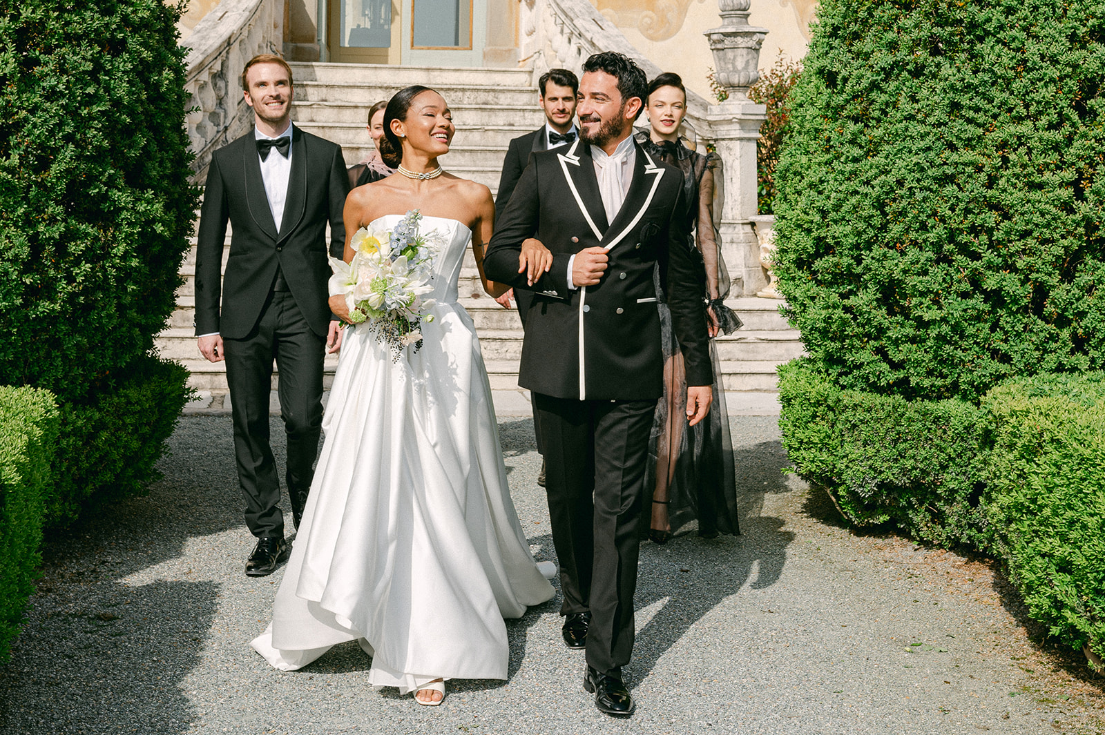 Bride and groom walking with their wedding party | candid documentary style photography.