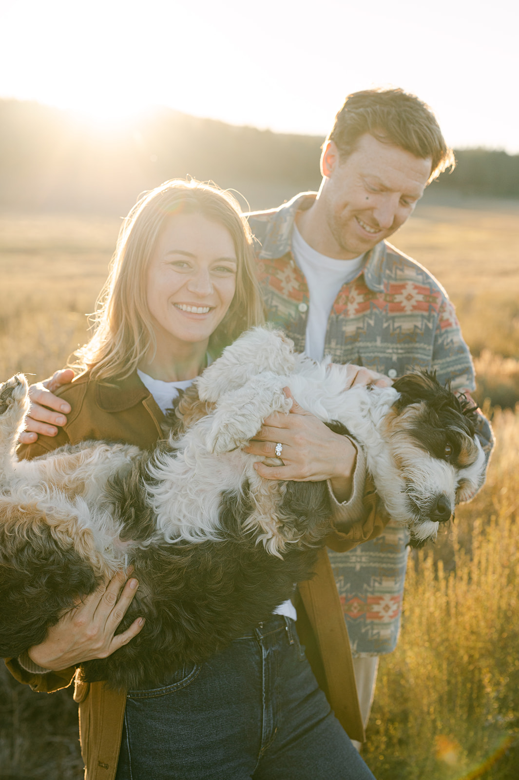 Couple holds their dog in their arms during Lake Tahoe photos.