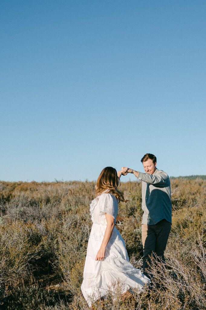 Couple walks through sagebrush during near Lake Tahoe.