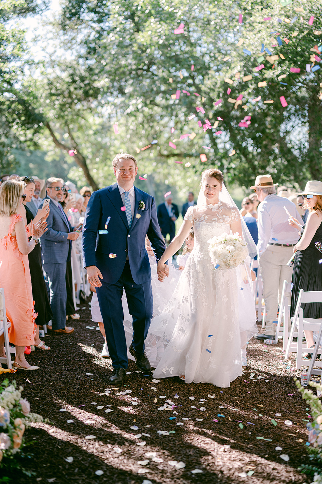 Couple walking down the aisle with colorful confetti at a summer wedding in Napa.