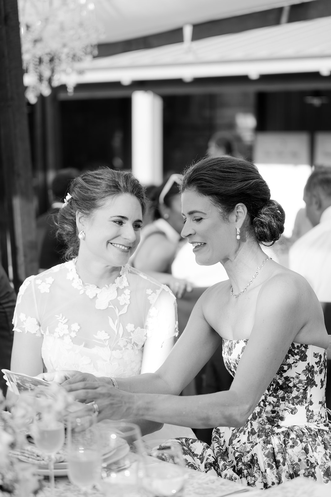 Bride and bridesmaid sharing a candid moment during reception.