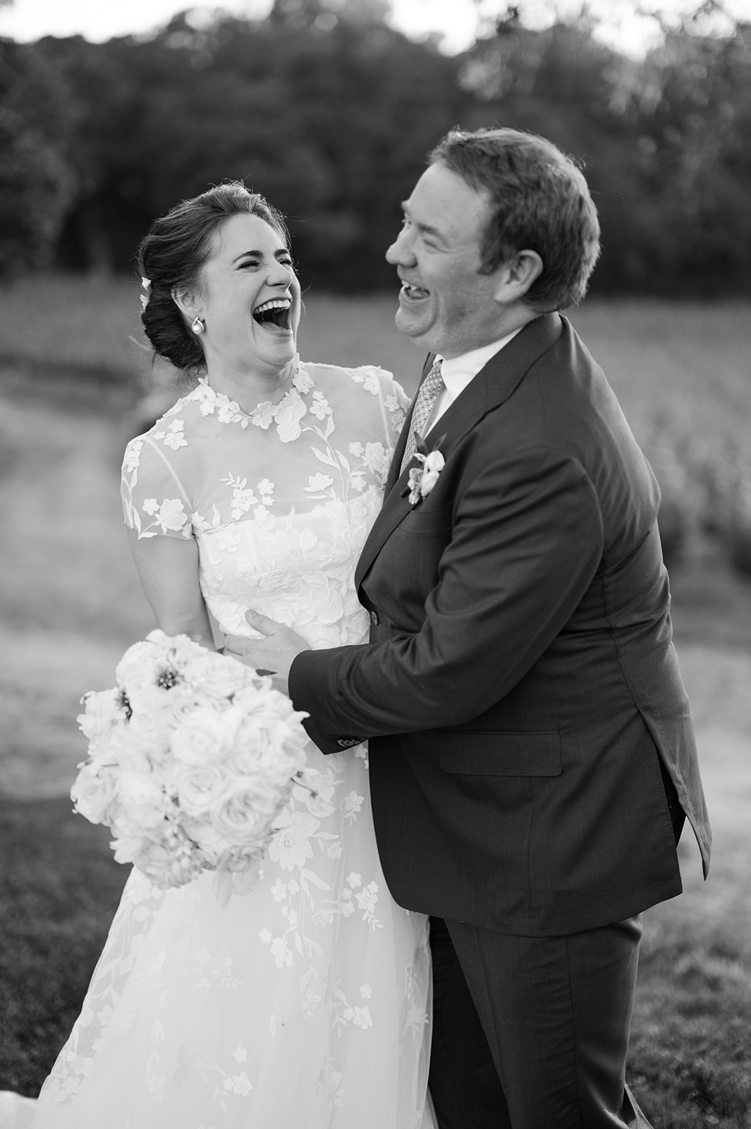 Bride and groom laughing together during sunset portraits.