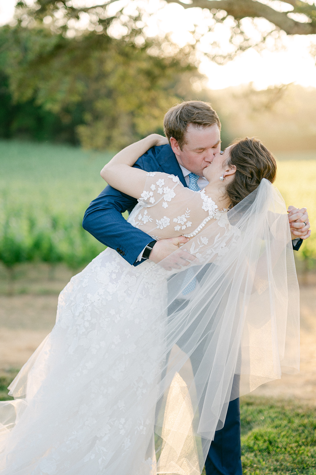 Bride and groom kiss during sunset portraits. 